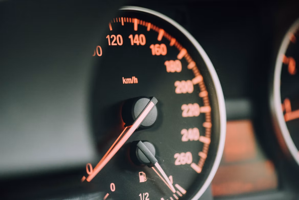 Cost of a car service in Australia orange-lit speedometer dial showing kmh