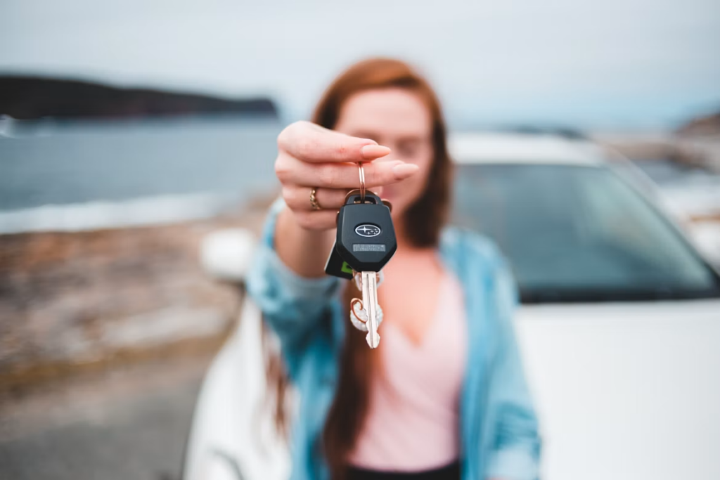 How to check a car's service logbook: a woman showing off a Subaru car key.