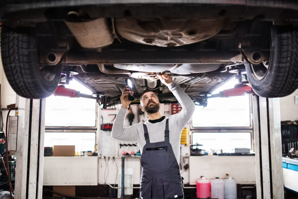 How to check a car's service logbook: mechanic inspecting car.