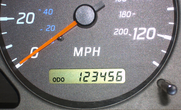 Log book service: car odometer showing 123456 miles on dashboard.