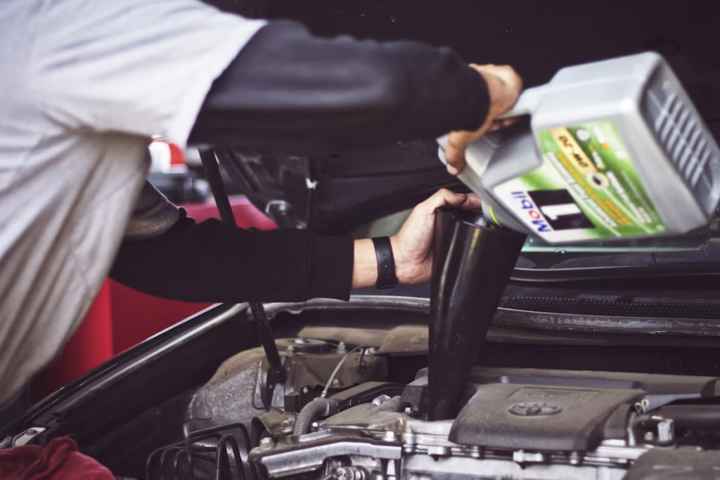 Mechanic pouring Mobil 1 oil into a Toyota engine during a service