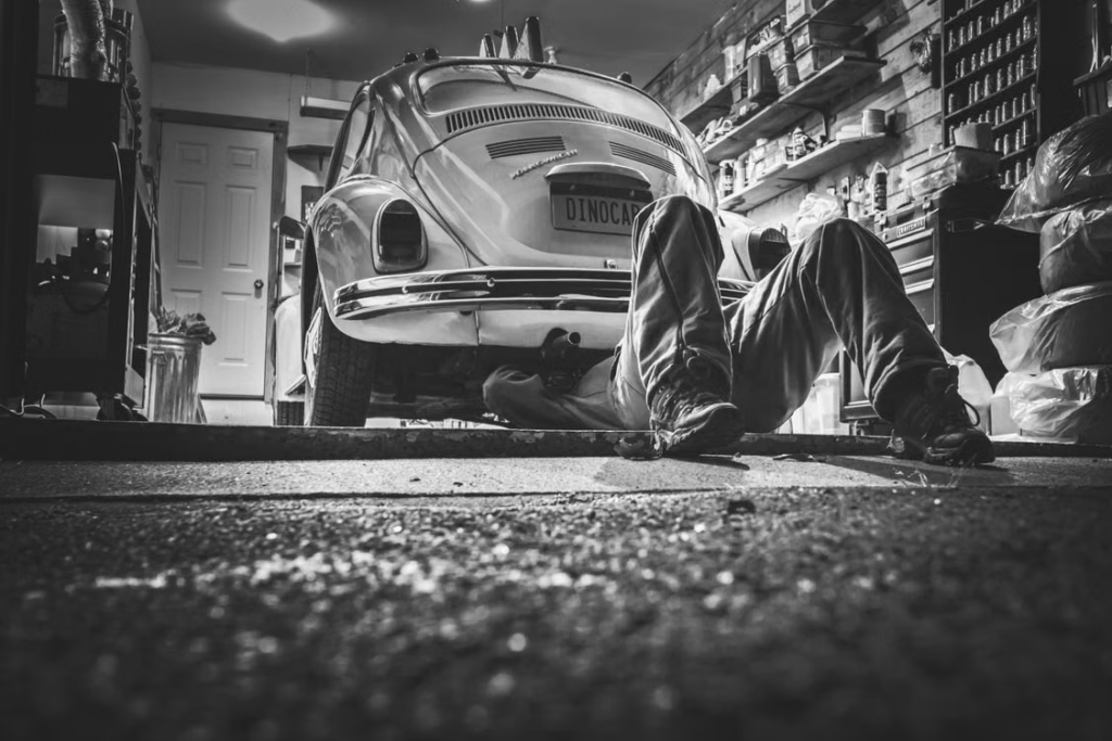 Car Maintenance Plans: a mechanic servicing underneath the car.