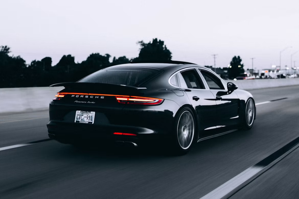 Transmission fluid replacement costs: a black Porsche car.